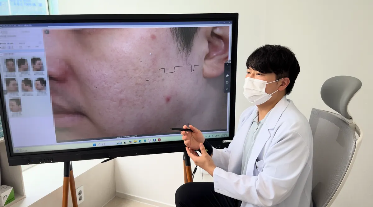 잠실피부과 의료진이 전자칠판에 띄운 볼 피부 사진을 보며 상담하는 모습